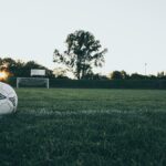 夕暮れのサッカーグラウンドとサッカーボール