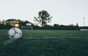 夕暮れのサッカーグラウンドとサッカーボール