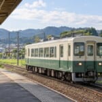 郊外を走る小さな電車と小さな駅のホーム