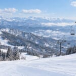 雪のスキー場のゲレンデとリフト、遠くの山並み