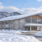 雪国の町並みと、雪をかぶった体育館